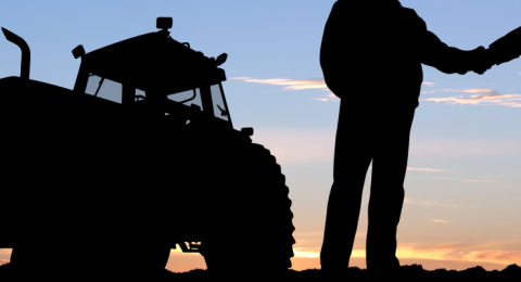 tractor and two farmers shaking hands